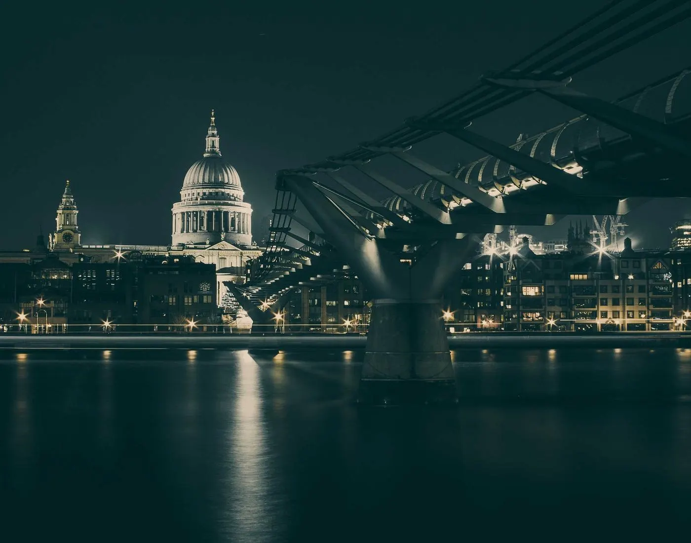 Cidade iluminada à noite com uma ponte sobre o rio, símbolo de conexão e crescimento